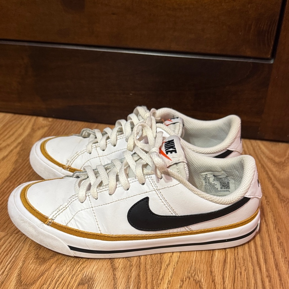 Nike White Sneakers with Black Swoosh and Gold Accent